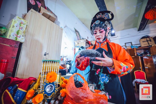 演员已基本装扮完毕，正微微低头整理道具，动作轻柔，眼神专注。记者 宋姿熠 .jpg